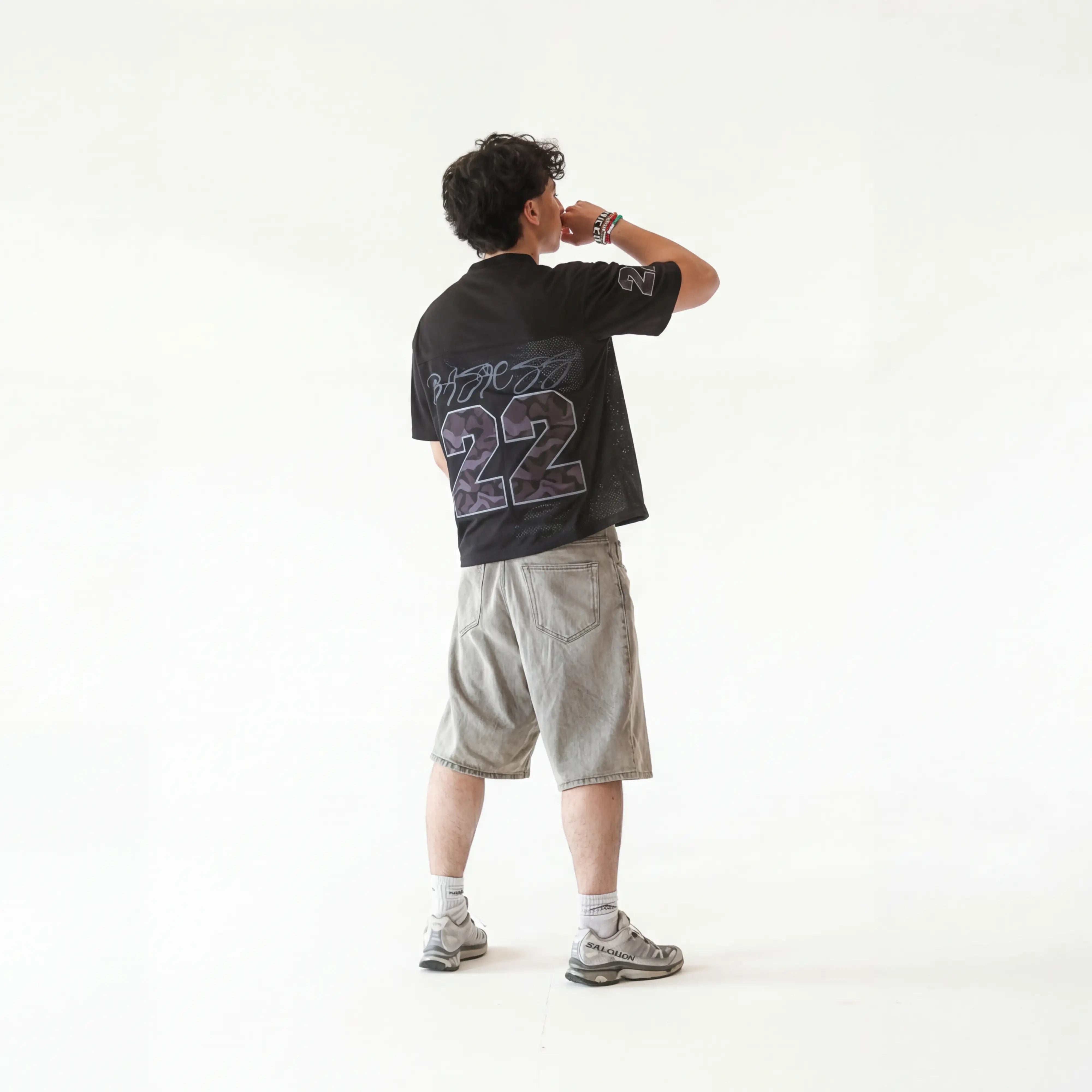 Person wearing a black t-shirt with '22' design on the back, standing against a white background